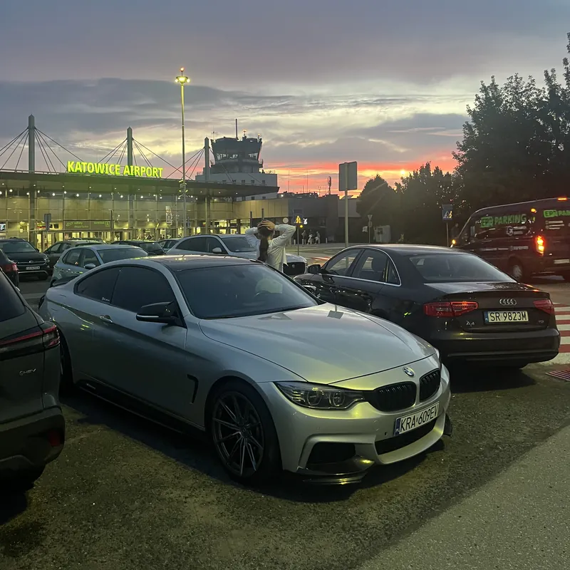 BMW przed lotniskiem Katowice Airport o zachodzie słońca - podróże zespołu Penthouse Office