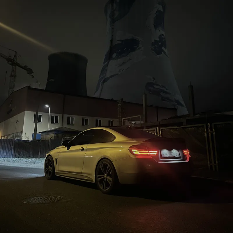 BMW nocą na tle chłodni kominowych - motoryzacja w wolnym czasie doradców Penthouse Office