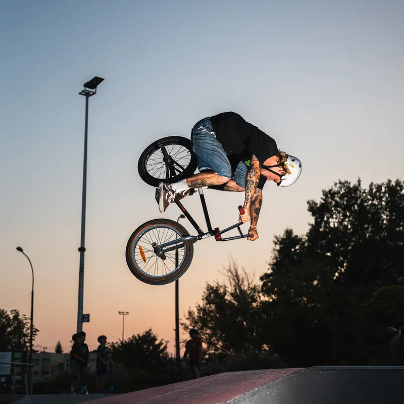 Trick na rowerze BMX na tle zachodu słońca - sport i adrenalina w zespole Penthouse Office